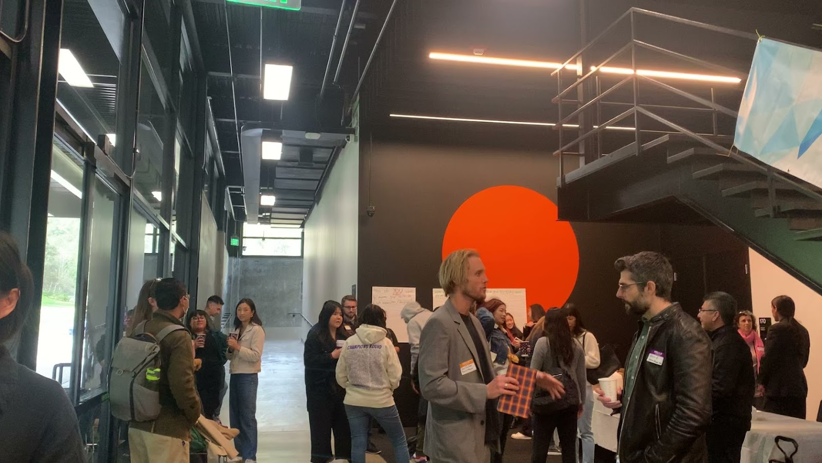 A crowd of people speaking to one another inside a building.