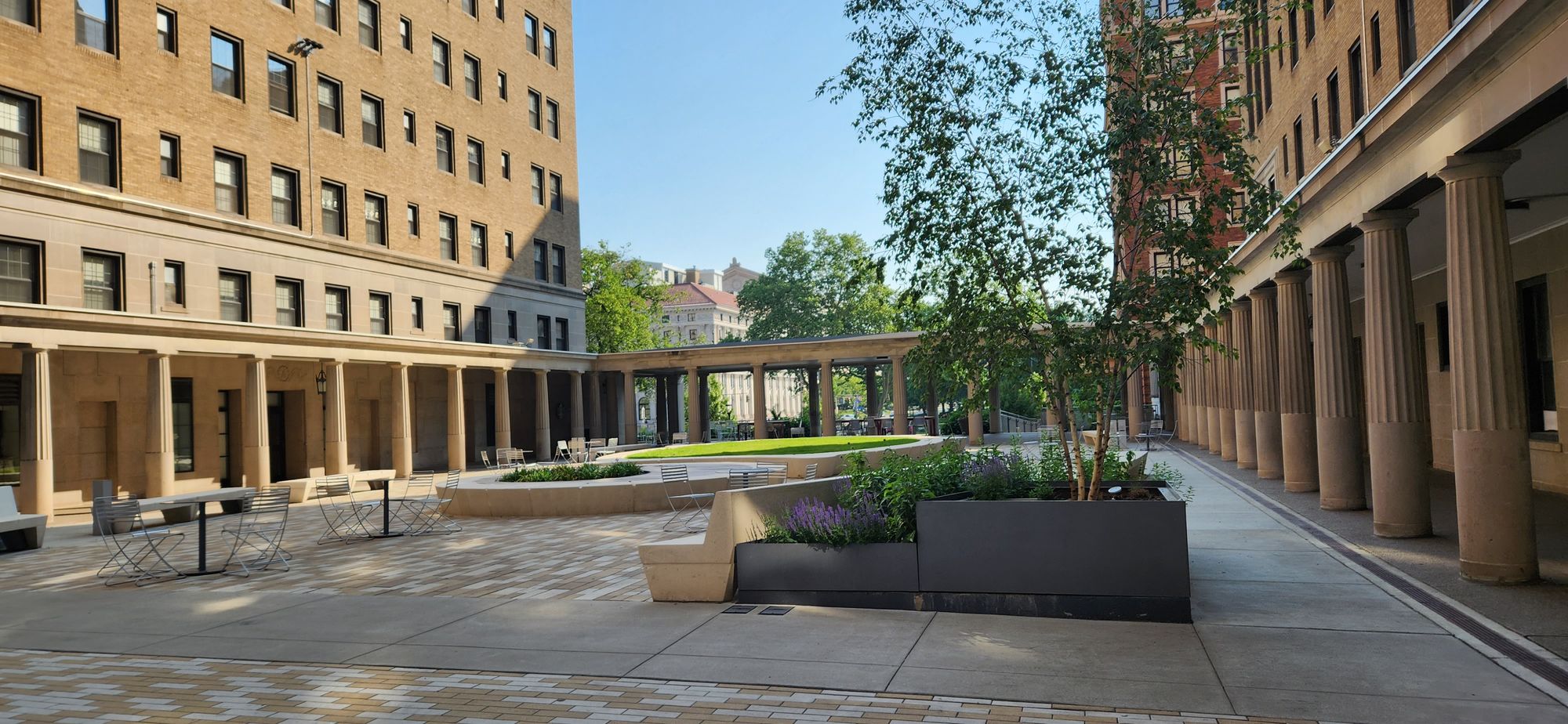 A courtyard with open-air halls held up by Greco-Roman style columns.