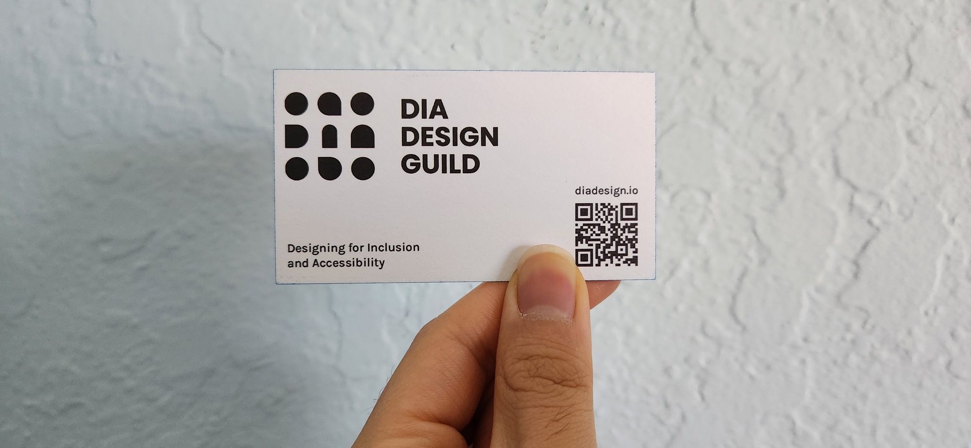 A black and white business card with a QR code. 